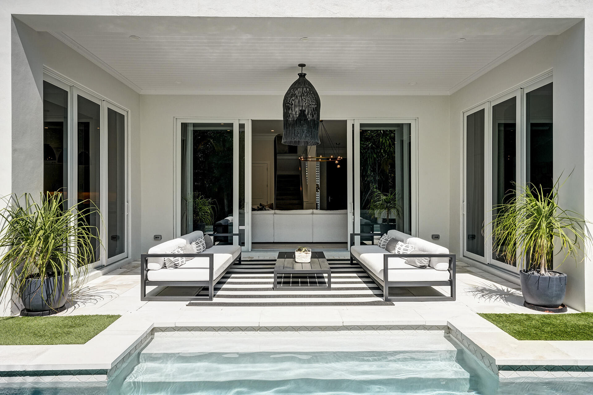 700 Northwest 6th Street Boca Raton, FL 33486 - Photo 32 of 40 a view of a house with swimming pool and couches chairs