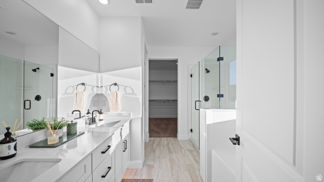 324 North Rhyolite Drive, Unit 87 Hurricane, UT 84737 - Photo 19 of 33 Full bathroom featuring double vanity, a shower stall, a spacious closet, and light wood-style floors
