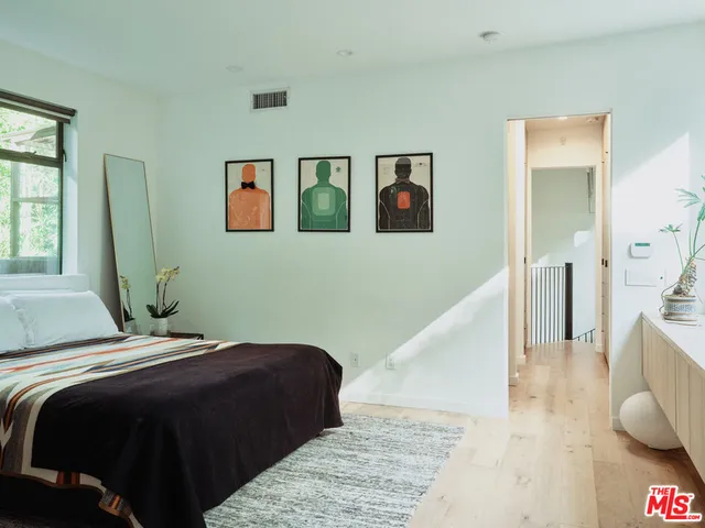 a bedroom with a bed and painting on the wall