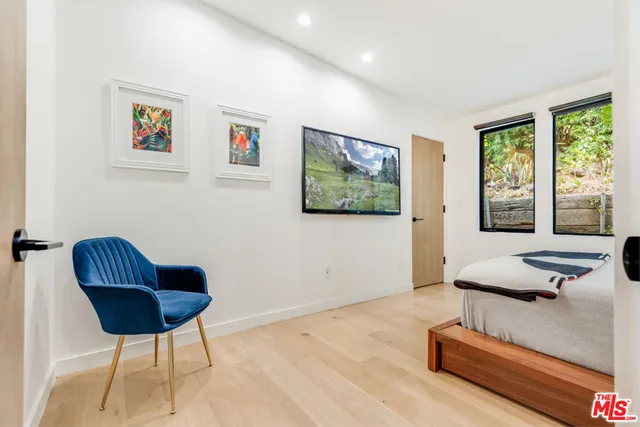 a bedroom with a bed and a painting on the wall