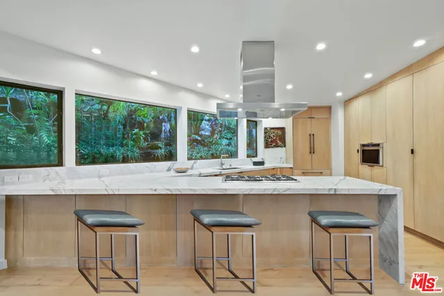 a kitchen with stainless steel appliances granite countertop wooden cabinets and a large window
