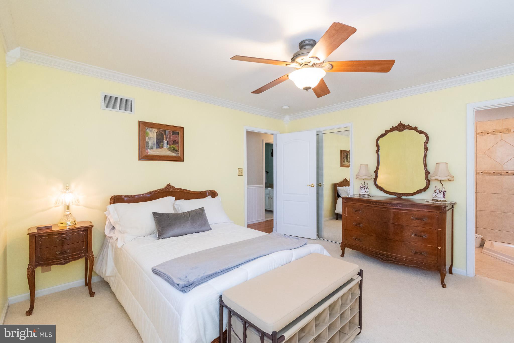 16550 Yeoho Road Sparks, MD 21152 - Photo 23 of 67 a bedroom with a bed a chandelier and a mirror