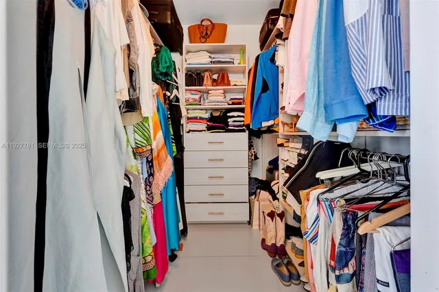 a view of walk in closet with clothes