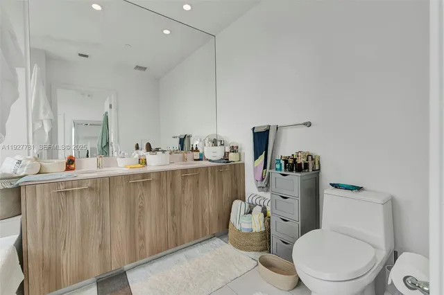 a bathroom with a sink mirror vanity and toilet
