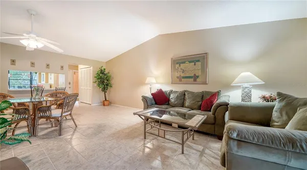 a living room with furniture a chandelier and a dining table