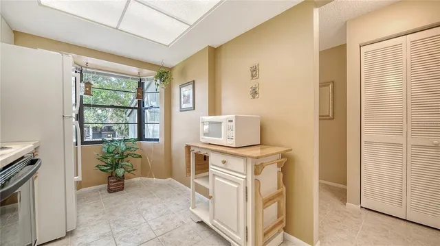 a view of a kitchen with fridge and front door