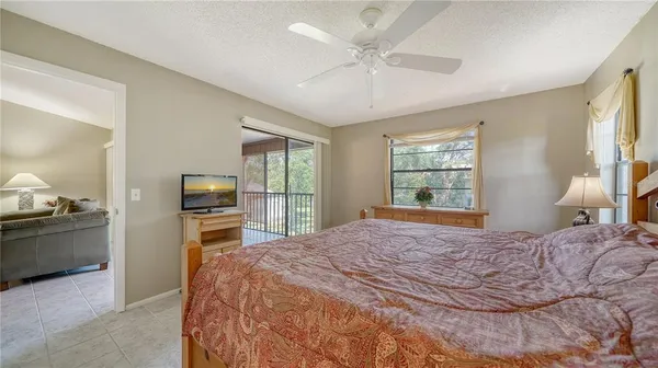 a bedroom with a bed a chandelier and a flat tv screen