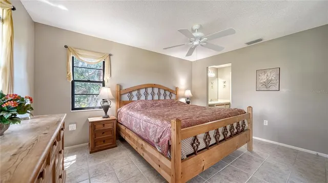 a bedroom with a bed chandelier and a window