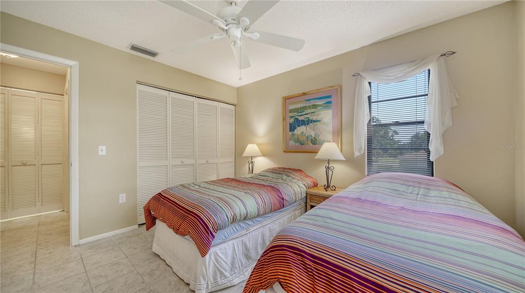5649 Summerside Lane, Unit 41B Sarasota, FL 34231 - Photo 27 of 41 a bedroom with two beds and a chandelier
