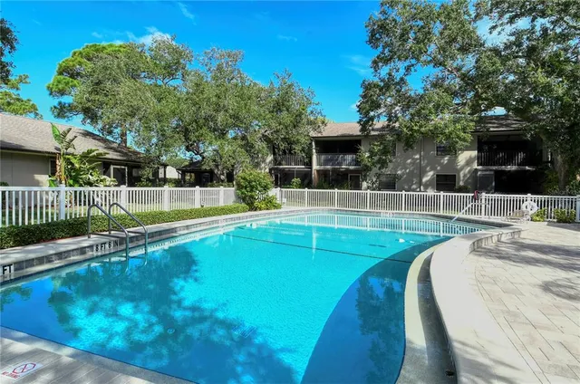 a view of backyard with wooden fence and large trees