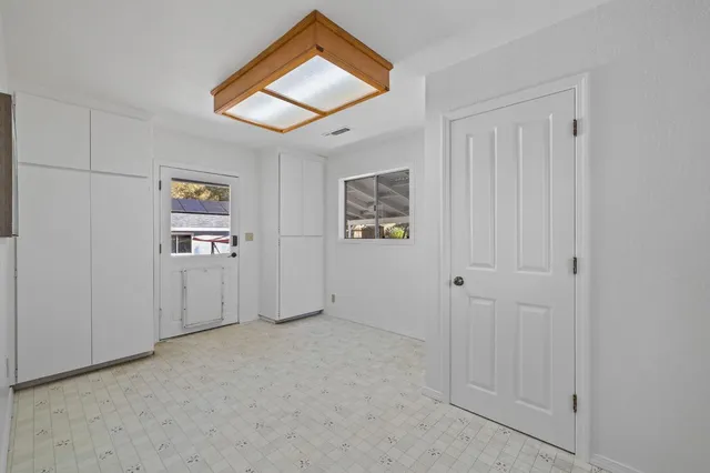 an empty room with closet and windows