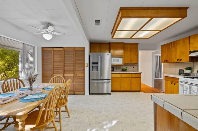 a kitchen with refrigerator cabinets and large windows