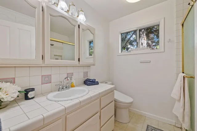 a bathroom with a toilet sink and mirror
