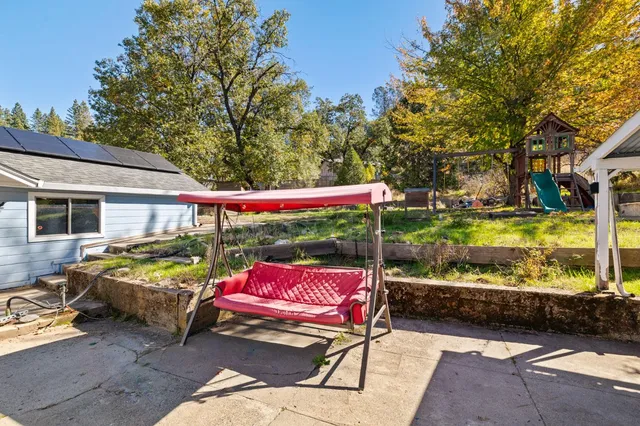 a view of a patio with table and chairs and floor to ceiling window