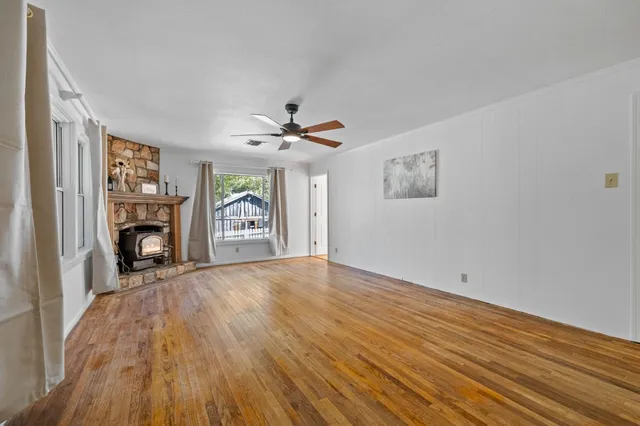 a view of an empty room with a fireplace and a window