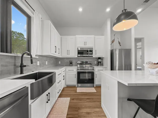 a kitchen with stainless steel appliances granite countertop a sink stove and refrigerator