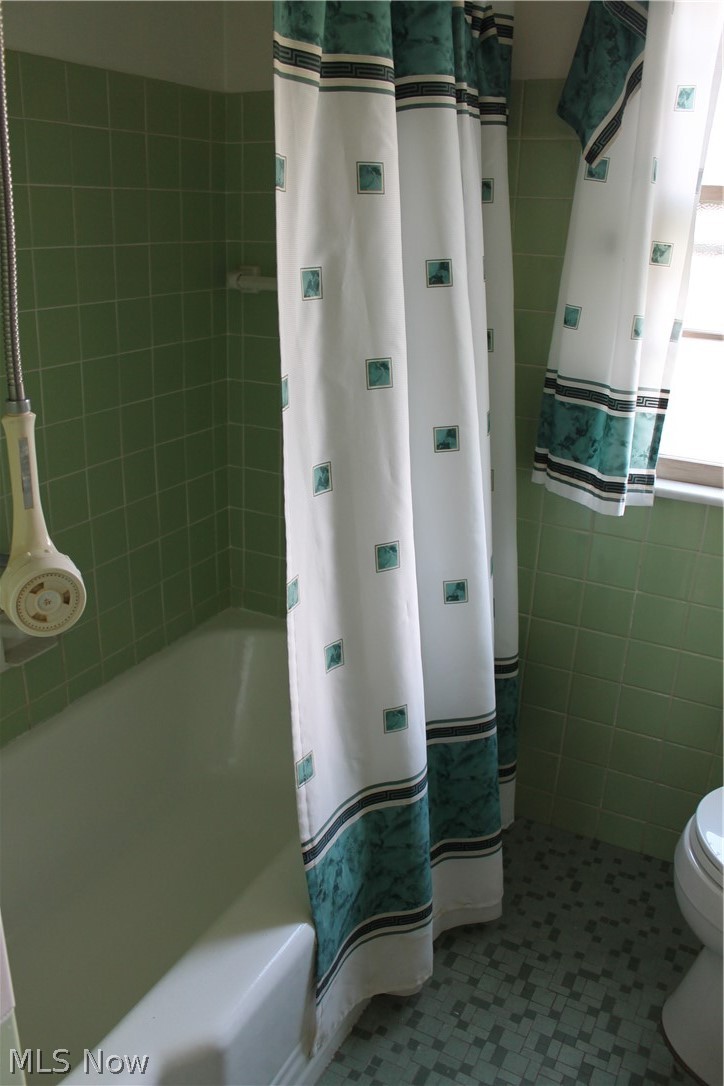 14863 Turney Road Maple Heights, OH 44137 - Photo 14 of 34 Bathroom with tile walls, shower / bath combo, toilet, water heater, and tile floors
