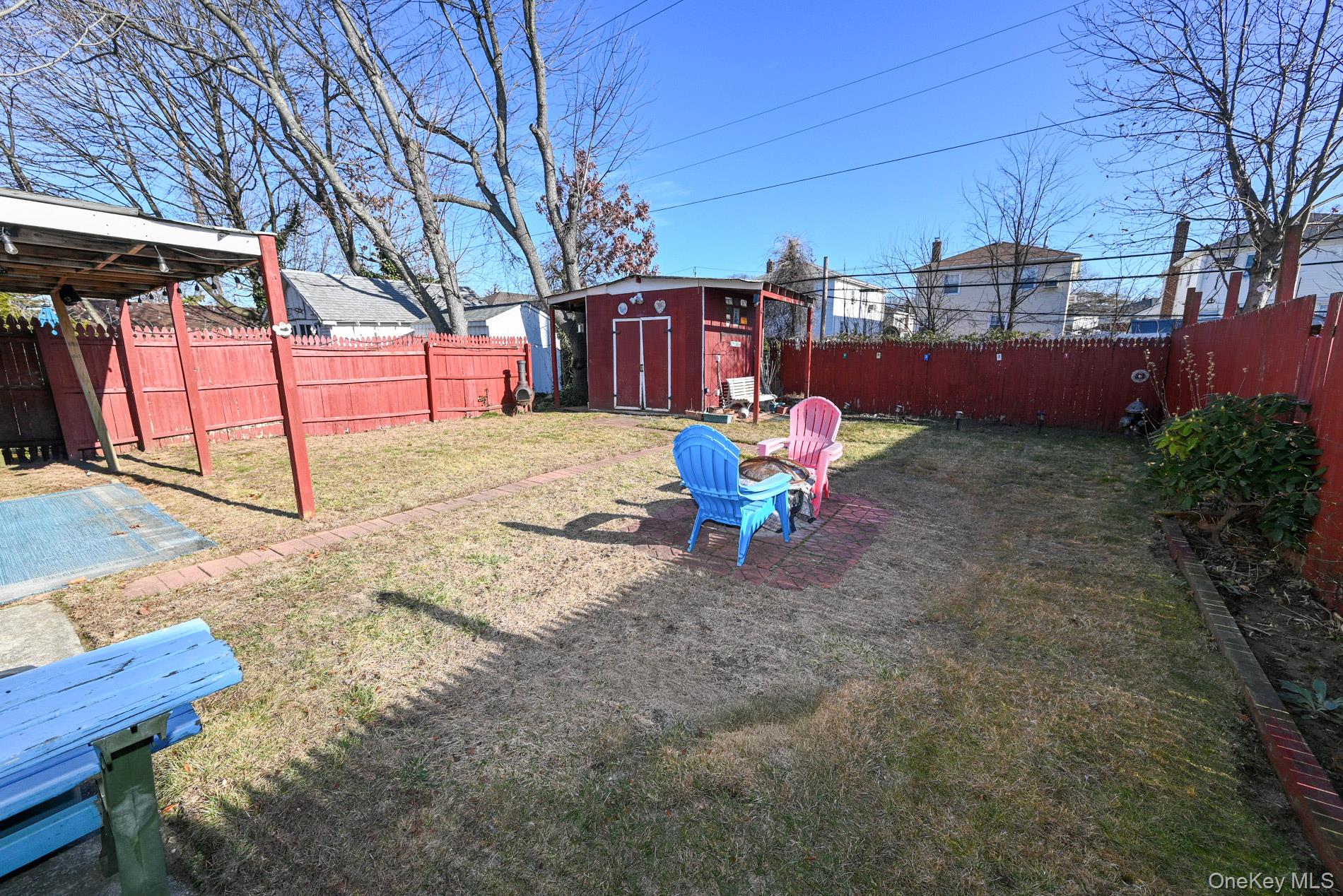 165 Cochran Place Valley Stream, NY 11581 - Photo 22 of 25 Fenced backyard with a storage unit and a fire pit