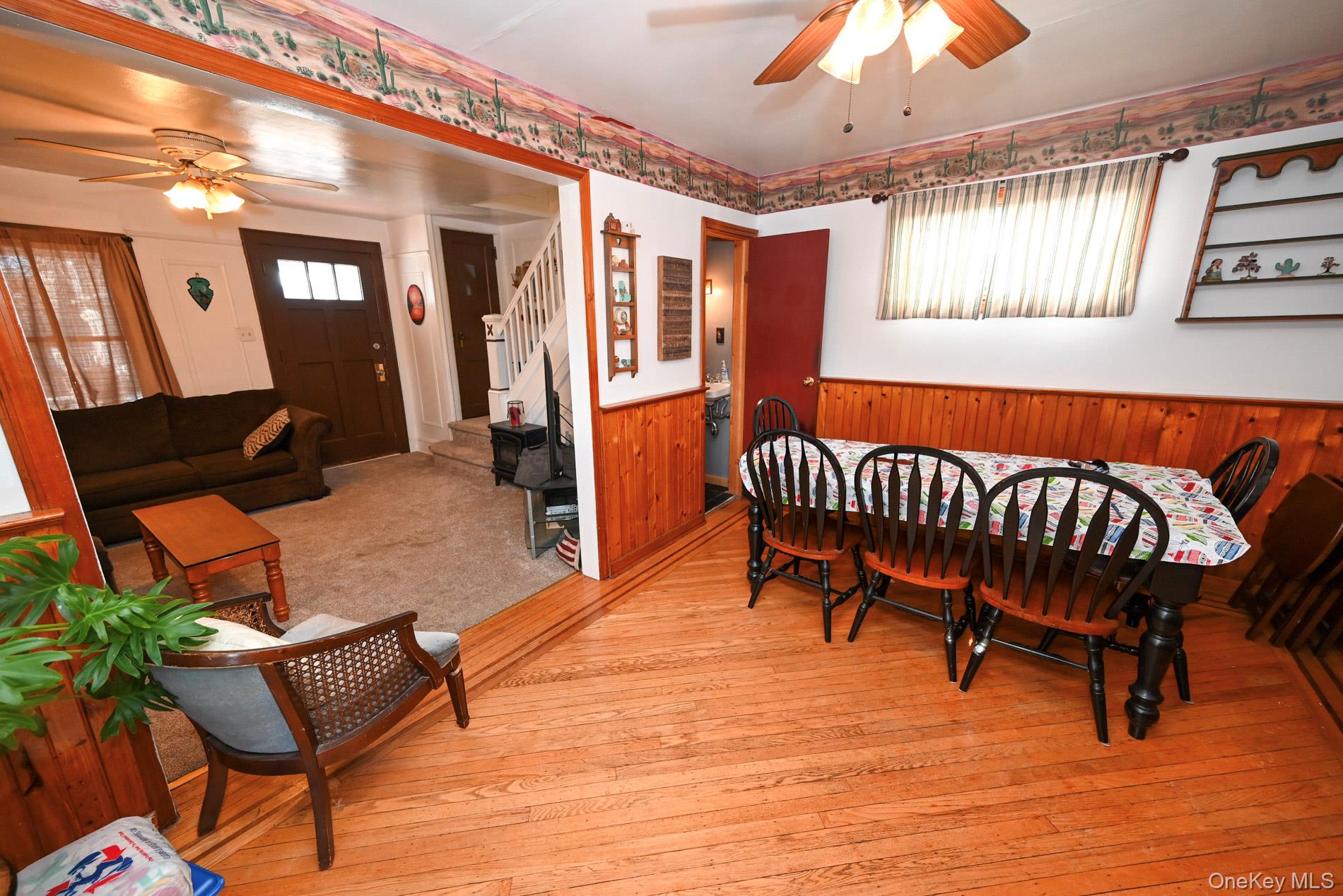 165 Cochran Place Valley Stream, NY 11581 - Photo 5 of 25 Dining area with ceiling fan, wainscoting, stairway, wooden walls, and wood-type flooring