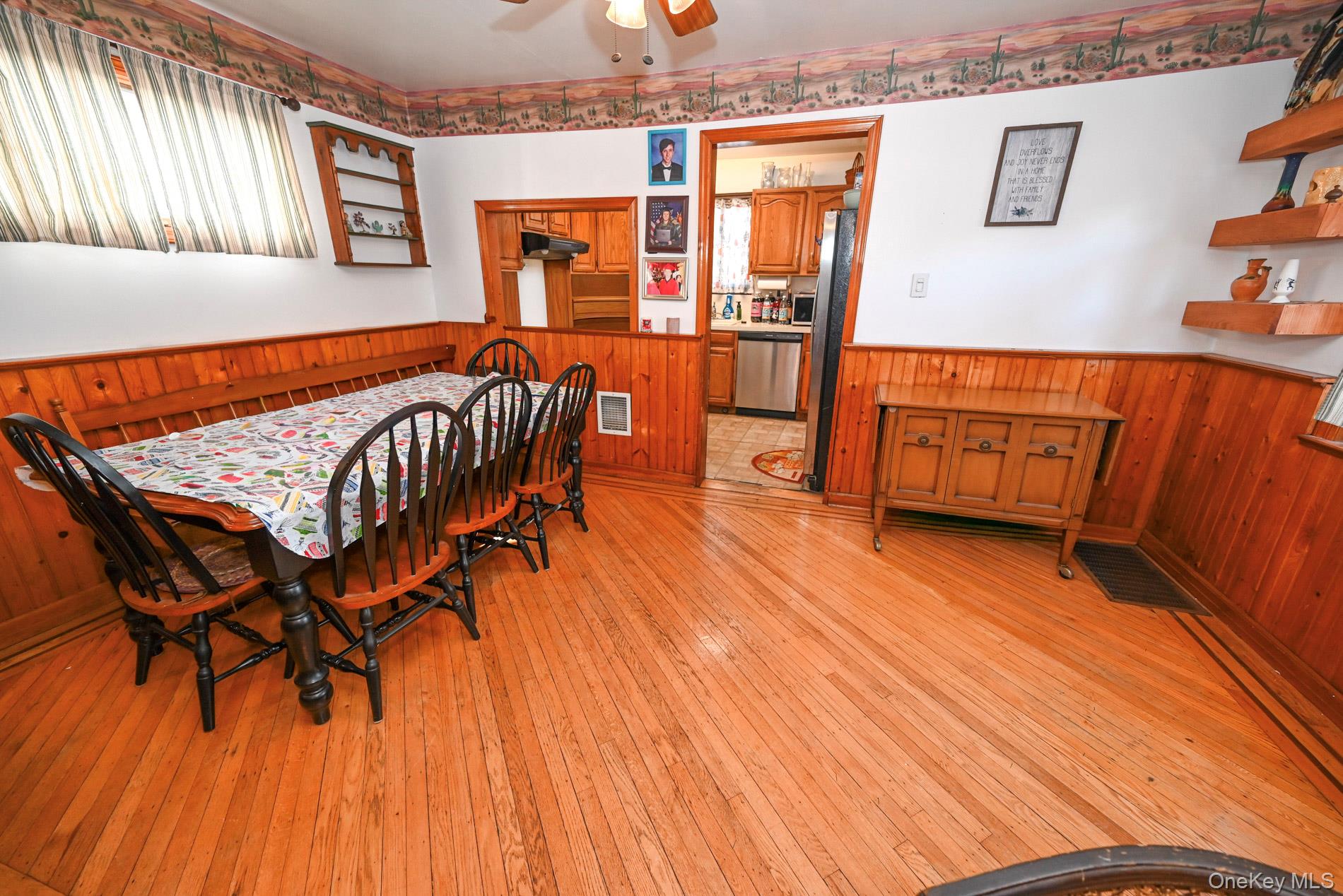 165 Cochran Place Valley Stream, NY 11581 - Photo 6 of 25 Dining space featuring wainscoting, wood walls, light wood finished floors, and a ceiling fan