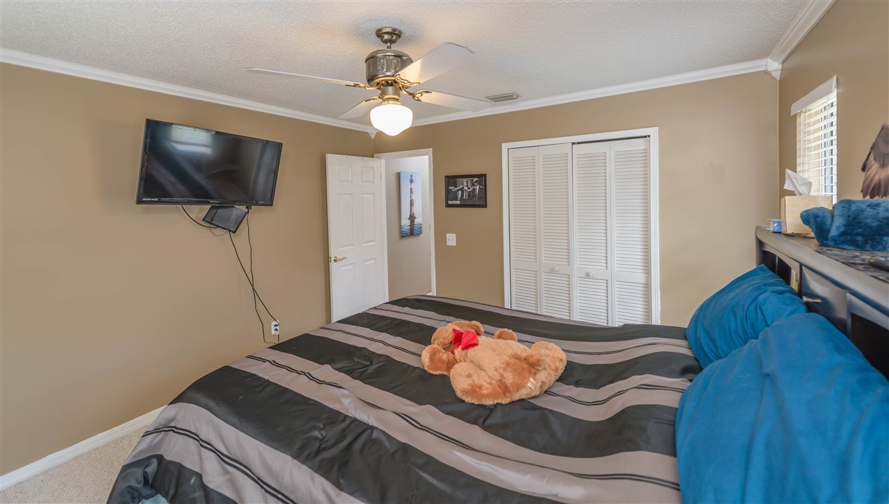 541 Moultrie Wells Road St. Augustine, FL 32086 - Photo 15 of 25 a bedroom with a bed and a flat screen tv