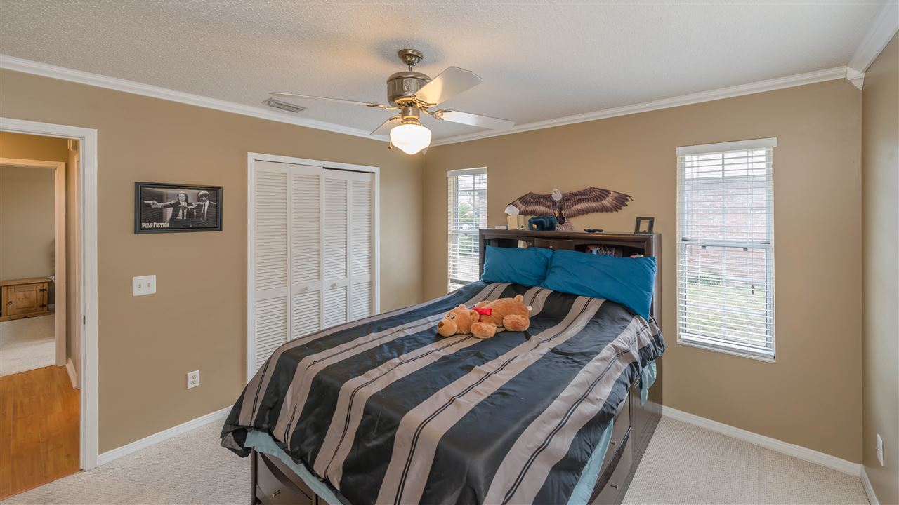 541 Moultrie Wells Road St. Augustine, FL 32086 - Photo 16 of 25 a bedroom with a bed and a chandelier