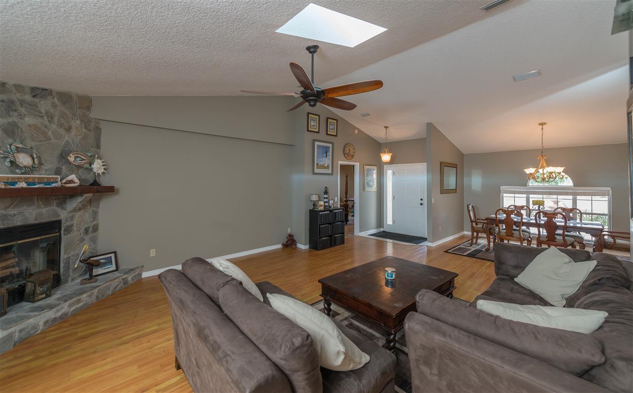 541 Moultrie Wells Road St. Augustine, FL 32086 - Photo 6 of 25 a living room with furniture a fireplace and a chandelier