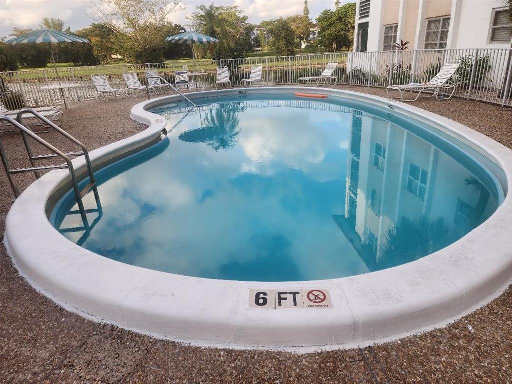 3591 Inverrary Drive, Unit 406 Lauderhill, FL 33319 - Photo 12 of 13 a view of a swimming pool with a yard and plants