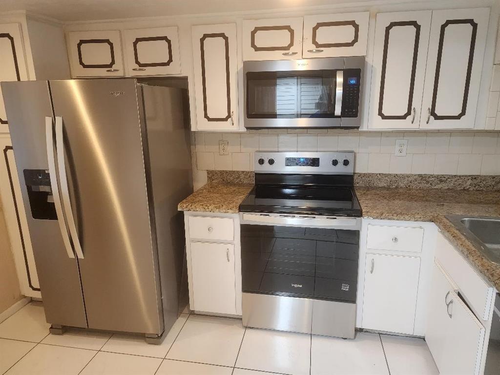 3591 Inverrary Drive, Unit 406 Lauderhill, FL 33319 - Photo 4 of 13 a kitchen with stainless steel appliances granite countertop a refrigerator stove and microwave