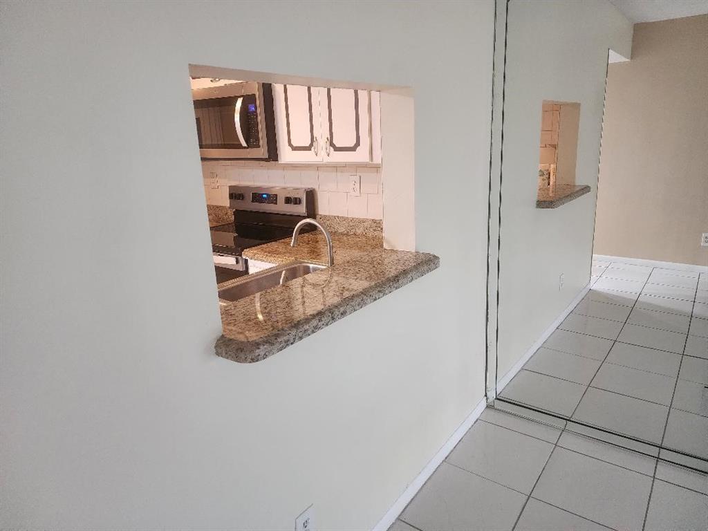3591 Inverrary Drive, Unit 406 Lauderhill, FL 33319 - Photo 5 of 13 a kitchen with granite countertop a sink and a stove