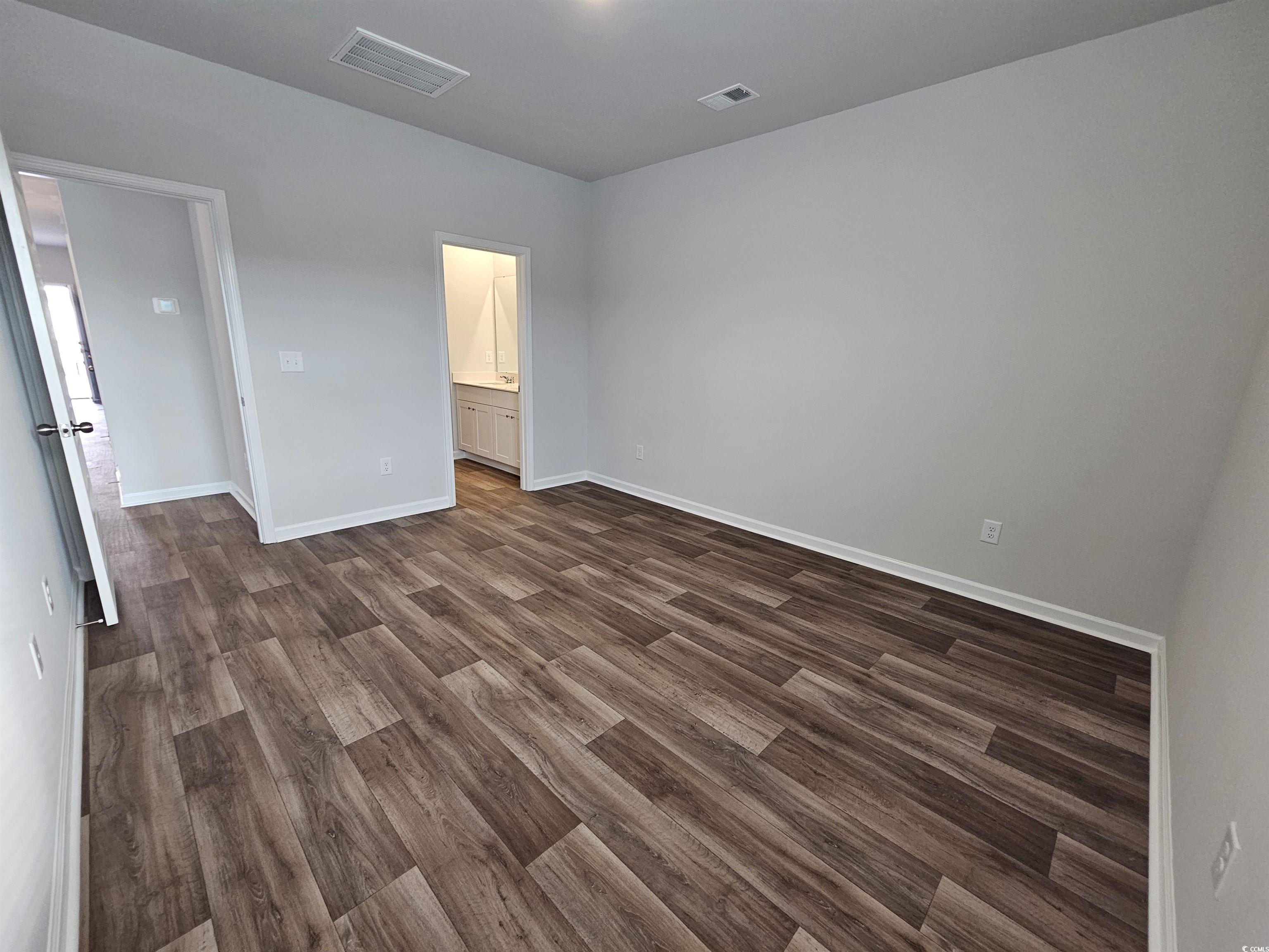 2100 Wild Indigo Circle Calabash, NC 28467 - Photo 15 of 31 Empty room with dark wood-style flooring and baseboards