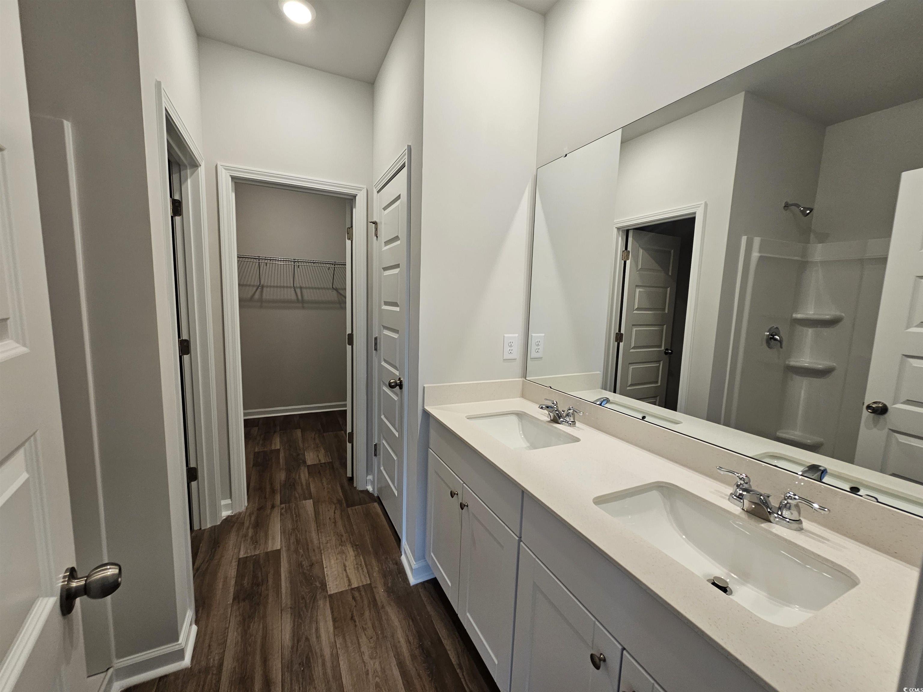 2100 Wild Indigo Circle Calabash, NC 28467 - Photo 16 of 31 Full bathroom featuring a walk in closet, double vanity, a shower, dark wood-style floors, and recessed lighting