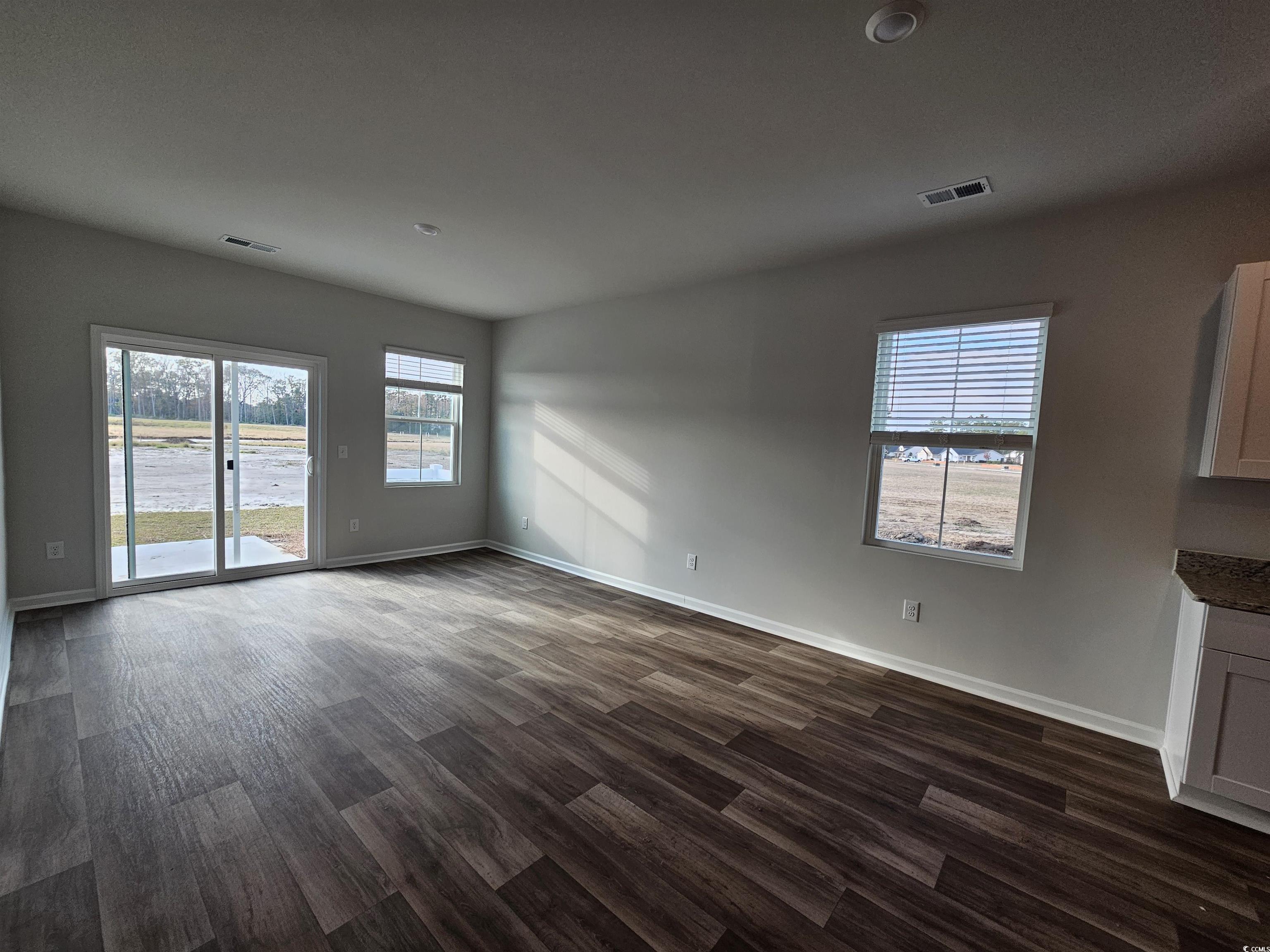 2100 Wild Indigo Circle Calabash, NC 28467 - Photo 8 of 31 Unfurnished living room featuring dark wood finished floors and baseboards