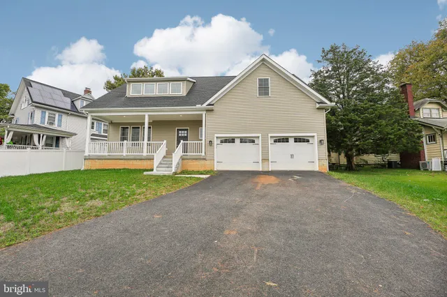 a view of a house with a yard and a large tree