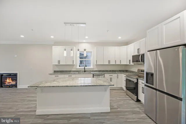 a large kitchen with stainless steel appliances granite countertop a stove a sink dishwasher and a refrigerator