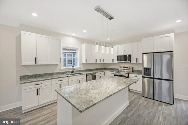 a kitchen with stainless steel appliances granite countertop a sink stove and refrigerator