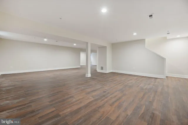 a view of an empty room with wooden floor