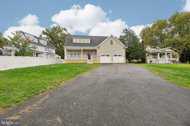 a view of a house next to a yard with big trees