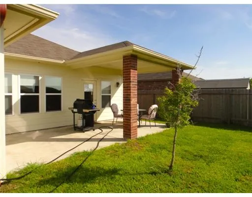 a backyard of a house with table and chairs