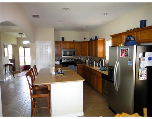 312 San Rafael Drive Portland, TX 78374 - Photo 4 of 10 a kitchen with stainless steel appliances granite countertop a refrigerator a stove a sink a dining table and chairs with wooden floor