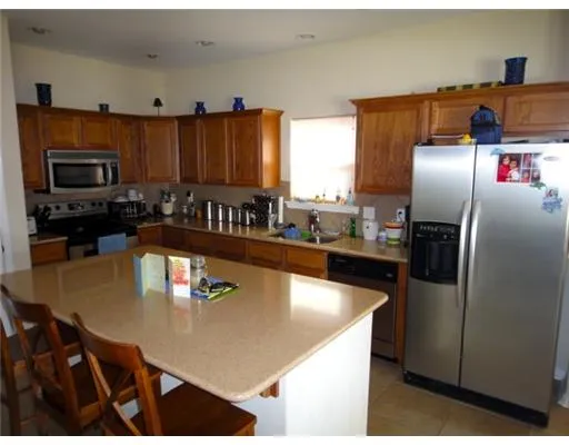 a kitchen with stainless steel appliances granite countertop a refrigerator a stove and a sink