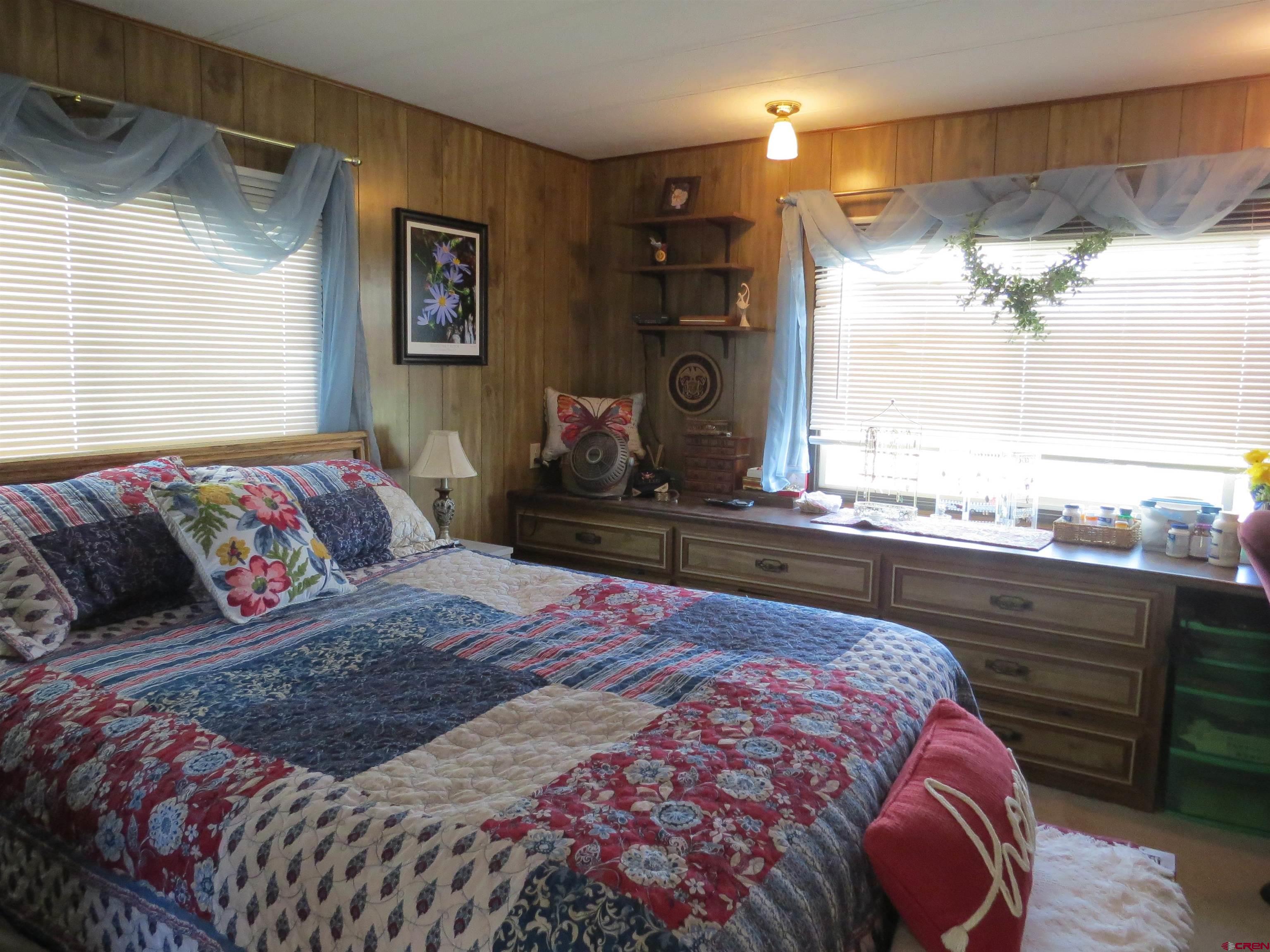 20028 Justice Road Austin, CO 81410 - Photo 12 of 22 a bedroom with a large bed and a chandelier