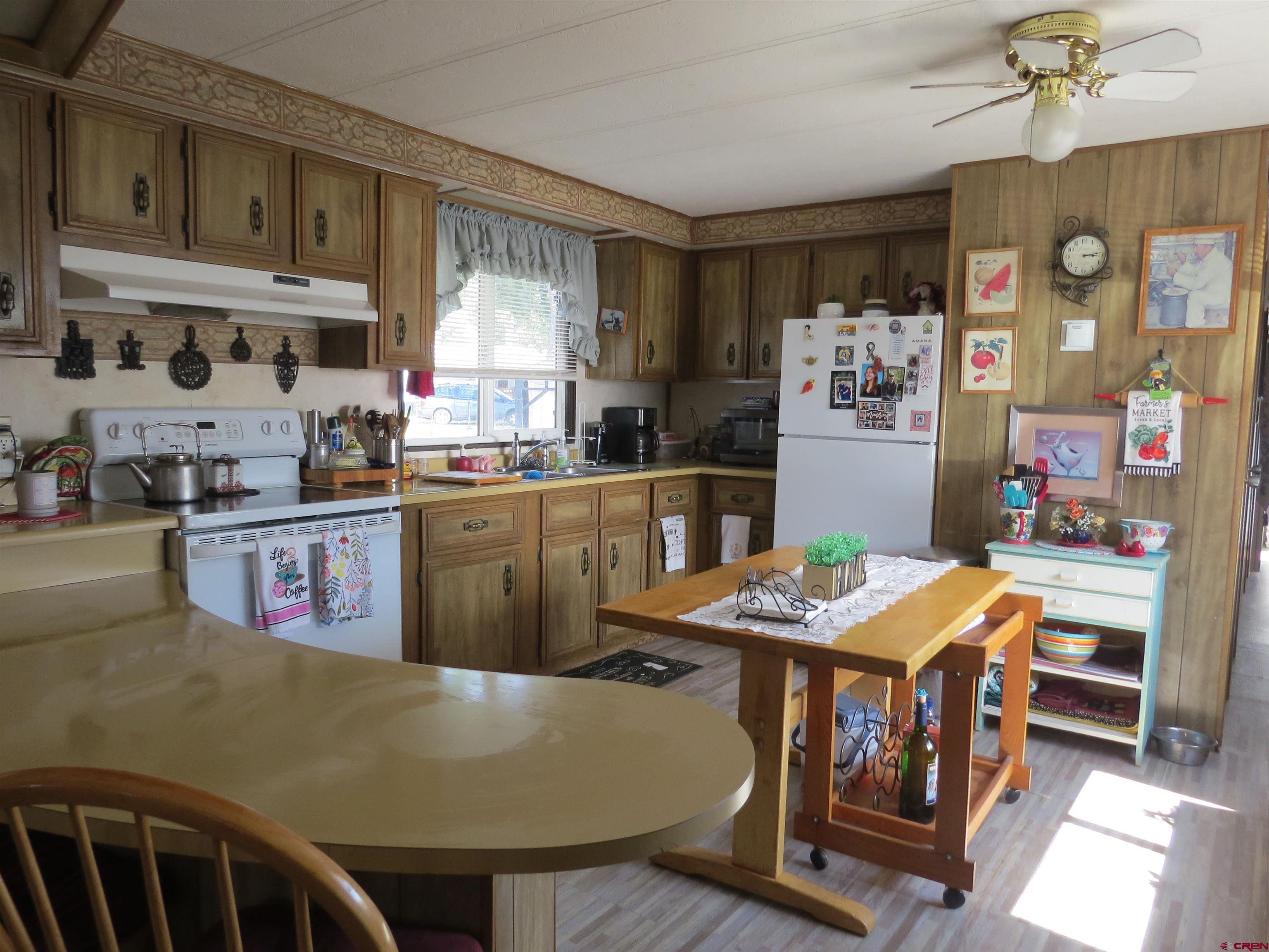 20028 Justice Road Austin, CO 81410 - Photo 8 of 22 a kitchen with stainless steel appliances granite countertop a stove a sink dishwasher and cabinets with wooden floor