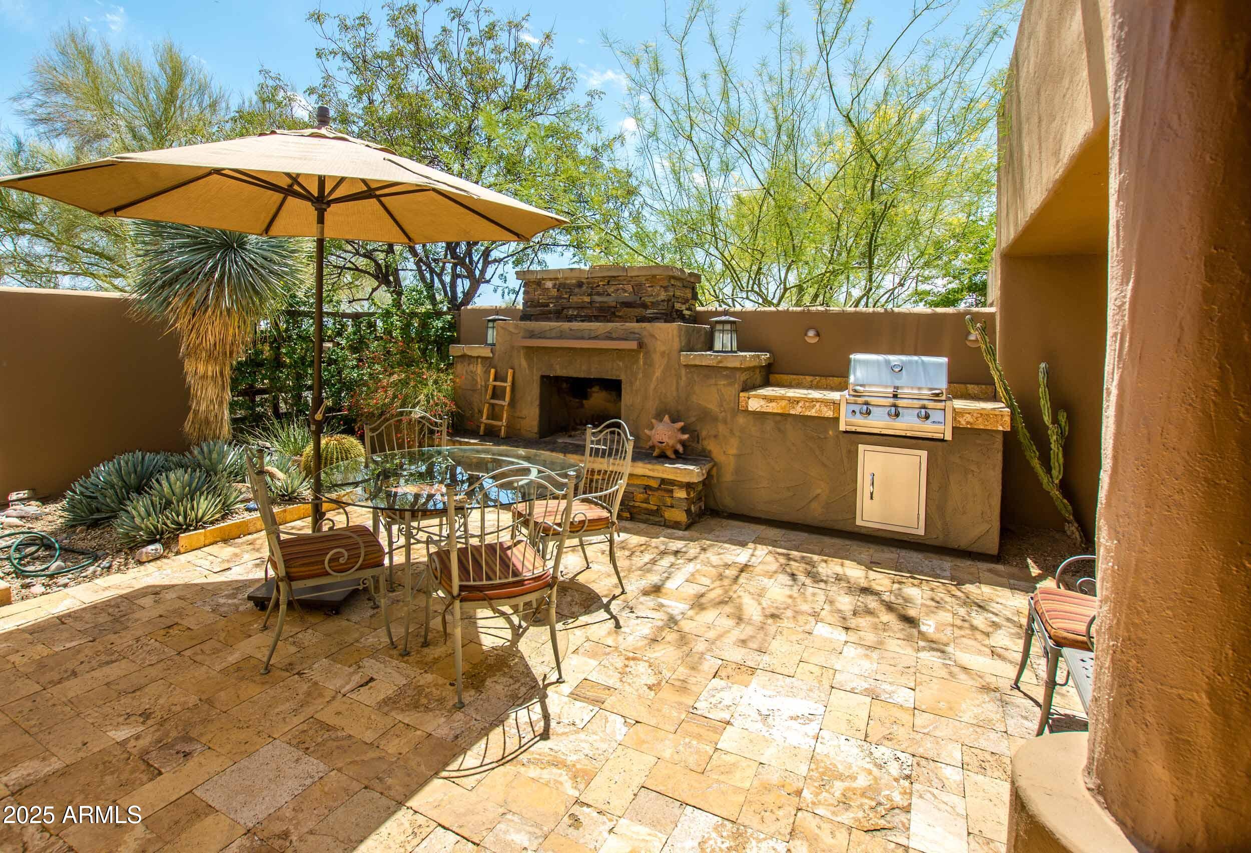8502 East Cave Creek Road, Unit 61 Carefree, AZ 85377 - Photo 26 of 52 a view of a patio with a table and chairs under an umbrella