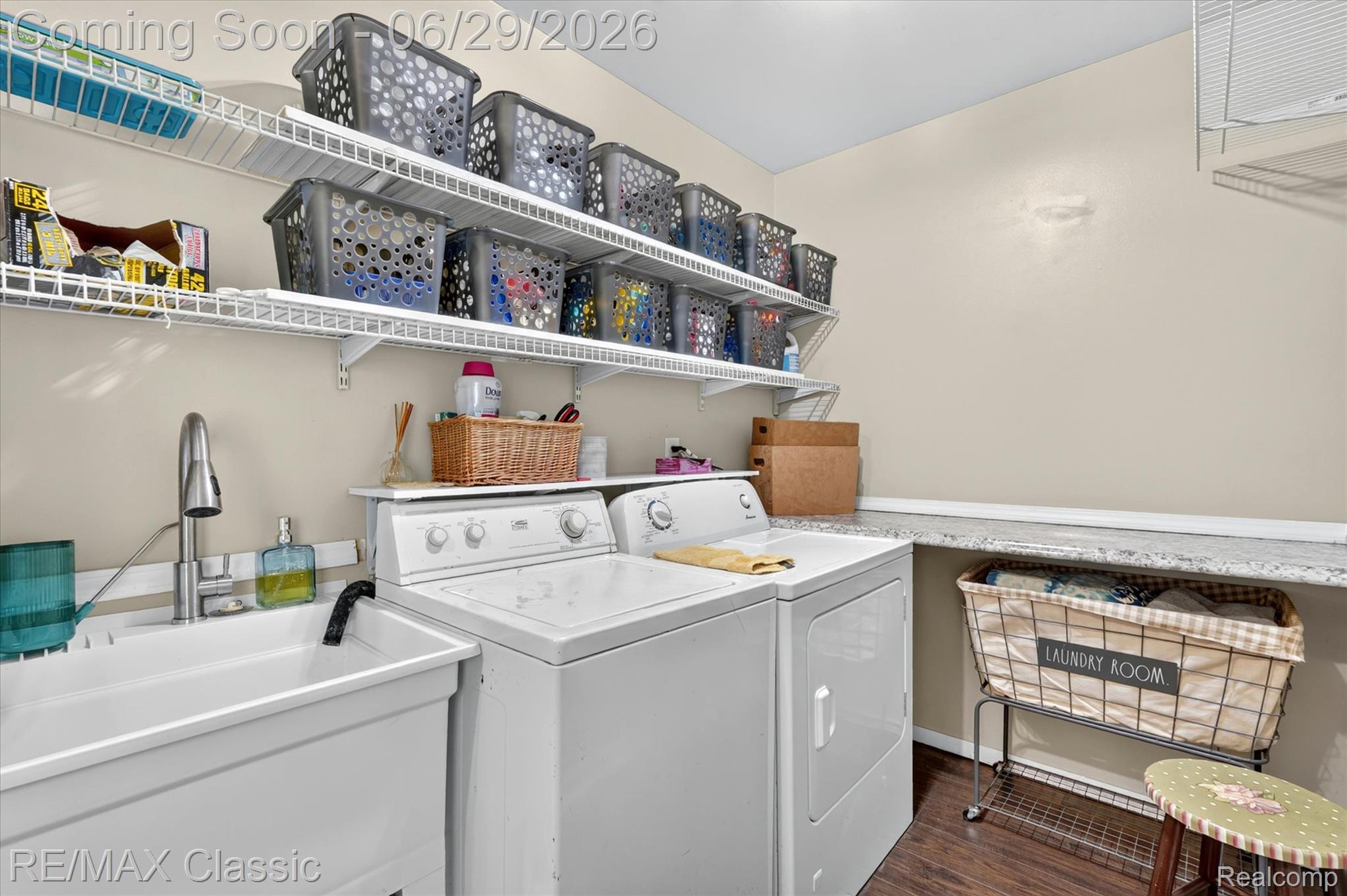 352 Meribah Road Highland, MI 48356 - Photo 29 of 39 Utility room featuring a utility sink with a chrome faucet, side-by-side appliances, and overhead wire shelving