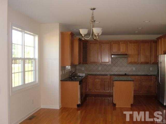 5220 Holly Ridge Farm Road Raleigh, NC 27616 - Photo 2 of 4 a kitchen with stainless steel appliances granite countertop wooden cabinets a stove a sink and a window
