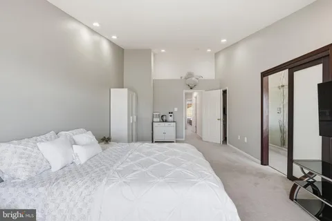 a large bedroom with a bed and a large mirror