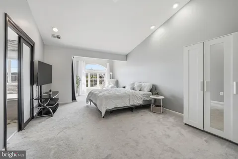 a bedroom with a bed and large mirror in it