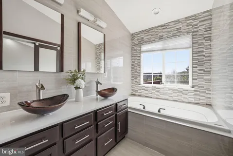 a bathroom with a granite countertop sink mirror and bathtub