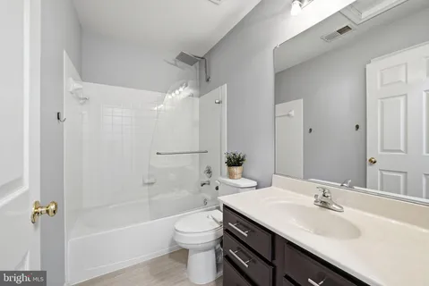 a bathroom with a sink a toilet a mirror and shower